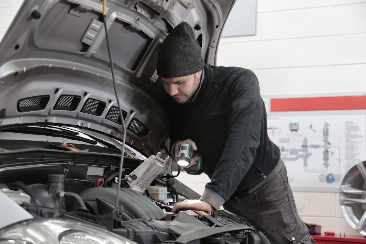 Wartungsarbeiten an einem Fahrzeug in der Hebebühne der Werkstatt